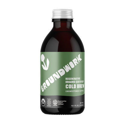 A dark glass bottle labeled Groundwork Coffee Co Regenerative Organic Certified® Cold Brew features a green label with white text and B Corp and Regenerative Organic certifications.