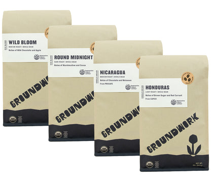 The Groundwork Coffee Regenerative Organic Certified® Coffee Bundle features four bags with unique flavor notes, including Nicaragua and Honduras, on white labels over kraft packaging.