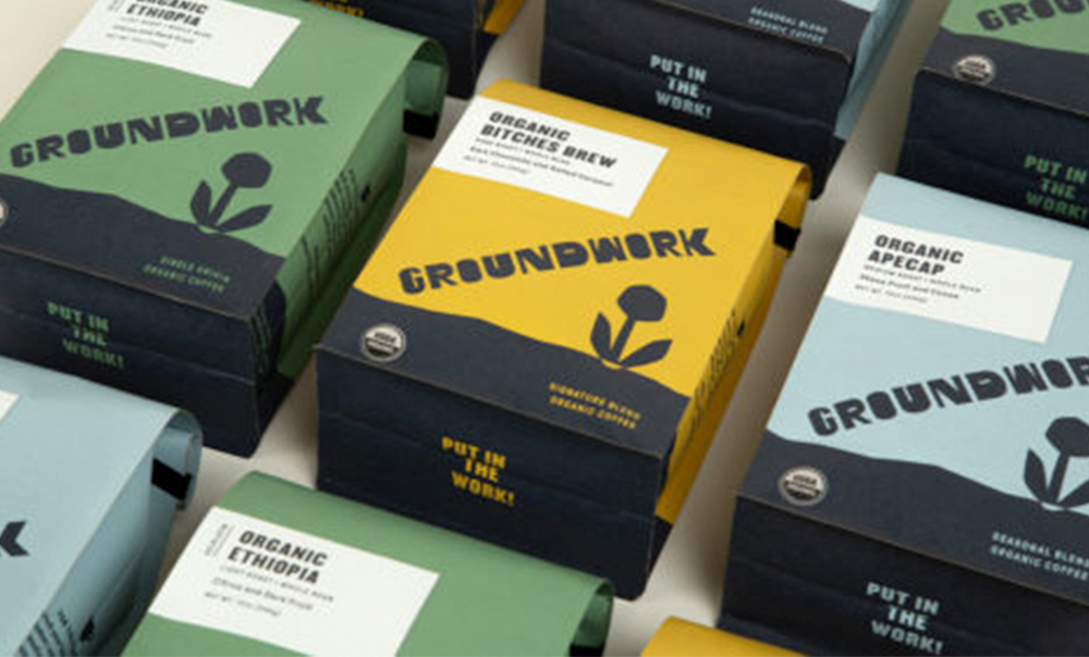 Boxes of Groundwork organic coffee in various colors, arranged in rows, each labeled with different blends like Bitches Brew and Ethiopia.