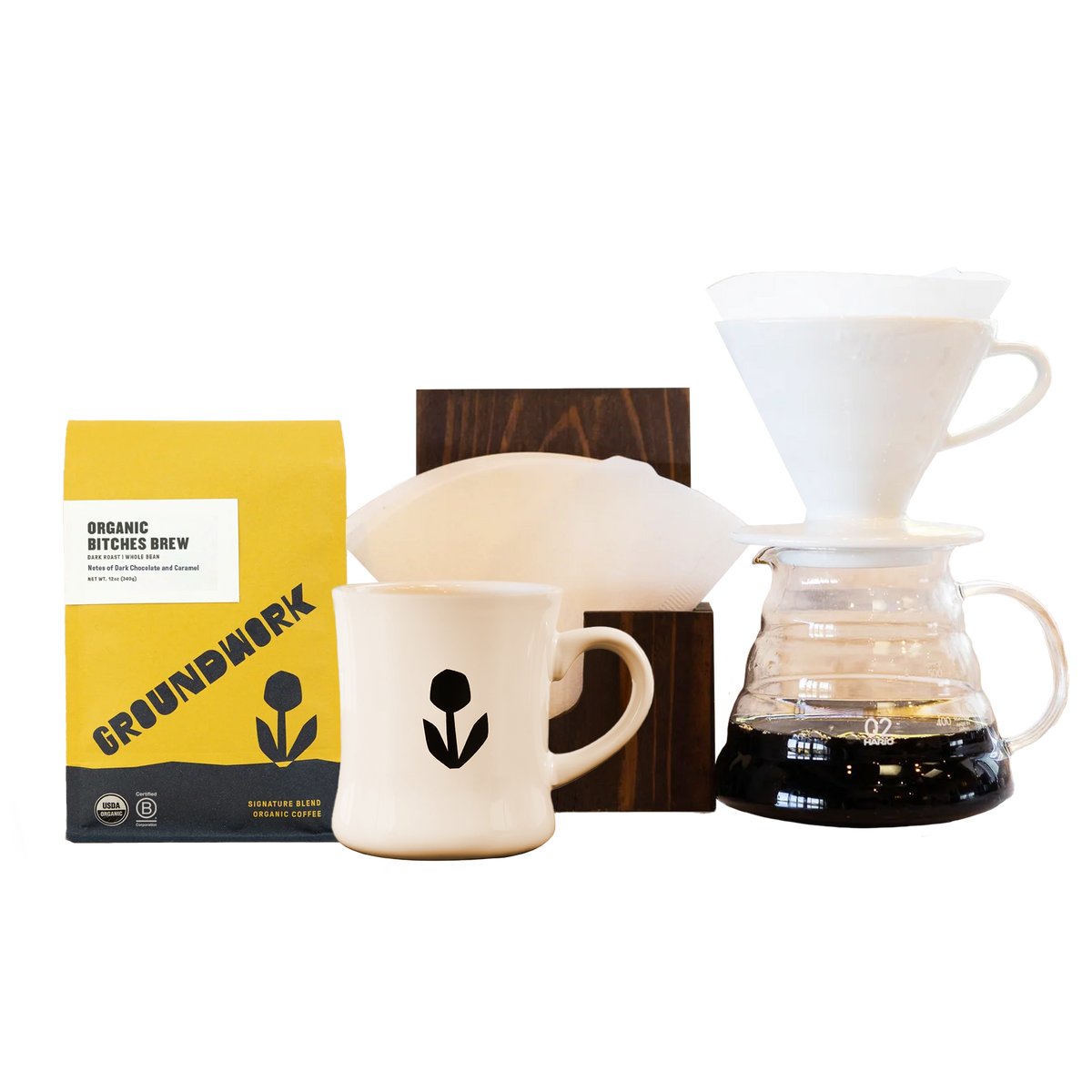 Coffee lovers will love the Hario V60 Pro Kit by Groundwork Coffee, with a yellow bag, mug, dripper, filter holder, and wooden stand on a white background.