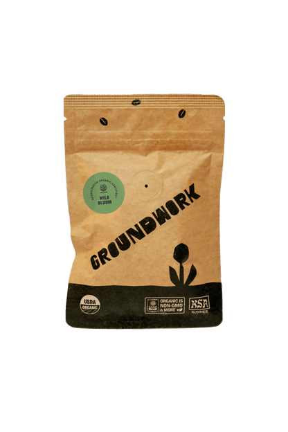 A brown bag of Groundwork Coffee, labeled Coffee Sample, features organic certification, sustainability logos, and is part of their Signature Blends collection.