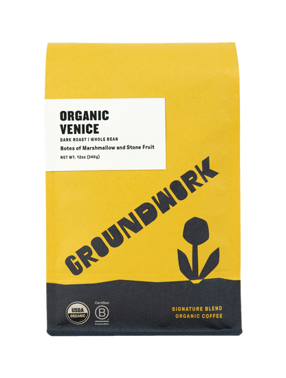 A yellow and white bag of Groundwork Coffees Venice Organic Dark Roast whole bean coffee featuring a tulip graphic and notes of marshmallow and stone fruit.